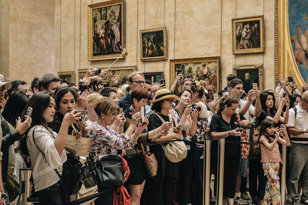 Crowds taking photos of art in the Louvre