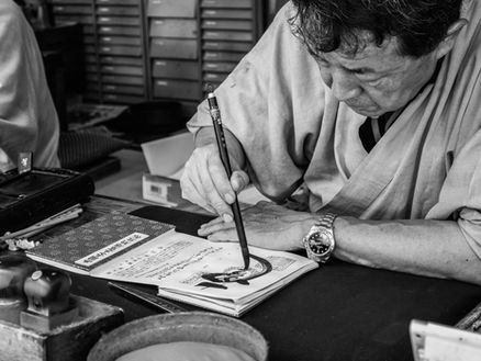 old man doing calligraphy