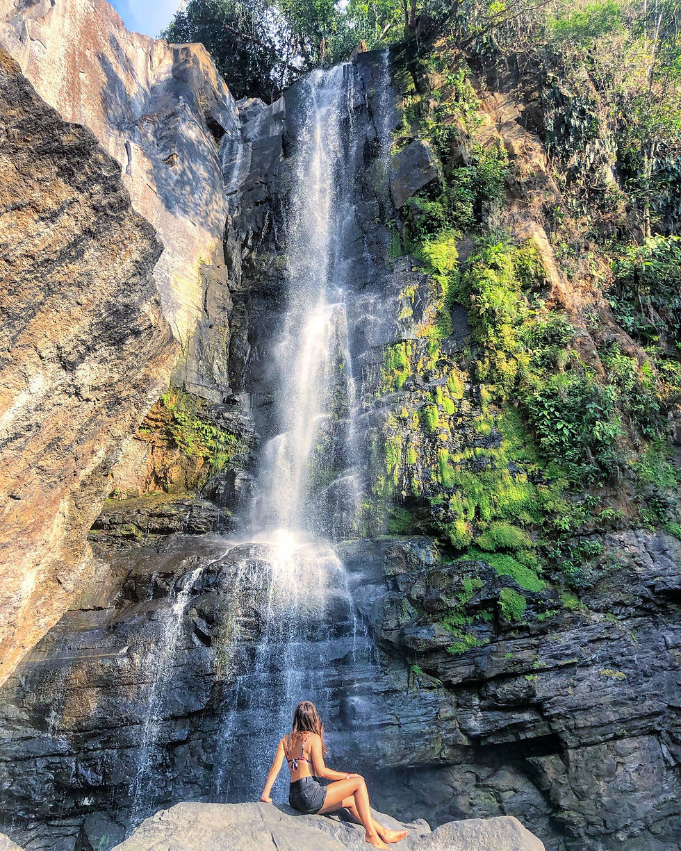 Woman gazing up at a waterfall in Costa Rica, feeling inspired