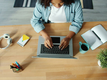 Woman sitting comfortably at home using a laptop for an online counselling or therapy session in a calm and private environment.