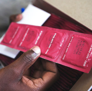 man holding a pack of condoms