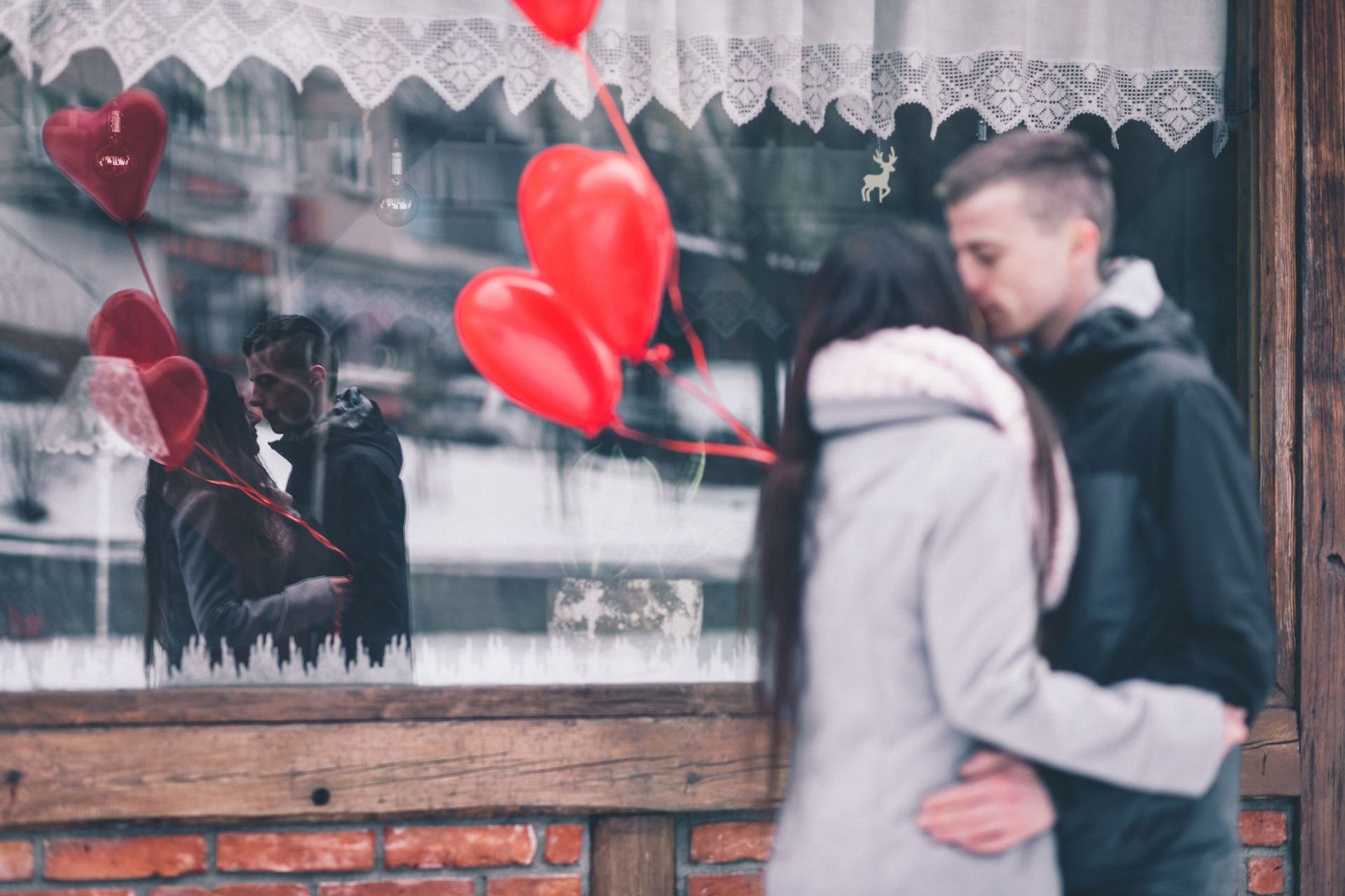 kissing lovers in ront of shop window