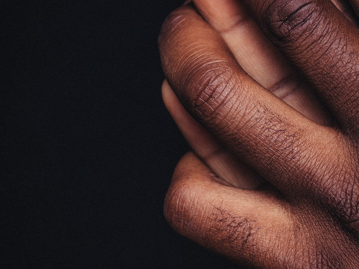 Close-up of a hand resting softly in shadow