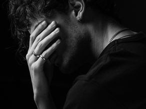 B/W image of a man with head in hands