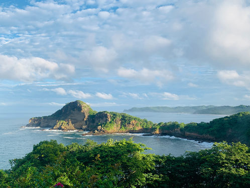 Panorama costiero del Nicaragua con baia, isolotti verdi e vegetazione tropicale in primo piano