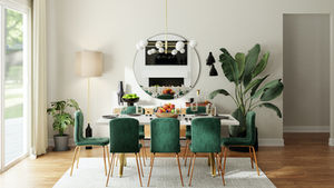 Dining room with a white table set for a meal, surrounded by green chairs. A round mirror, plants, and beige walls create a cozy ambiance.