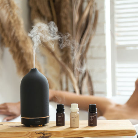 A woman relaxing in bathtub while diffusing essential oils to relax.