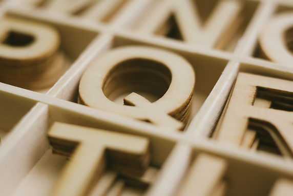 A selection of wooden letters with a Q featured in the centre.