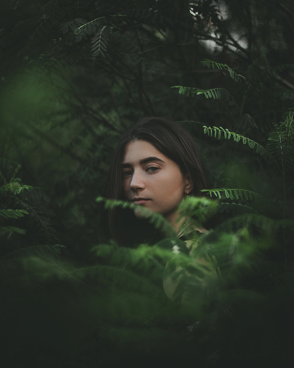 mulher de cabelos soltos no meio de uma vegetação alta