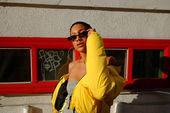 Woman wearing a vibrant yellow jacket and sunglasses