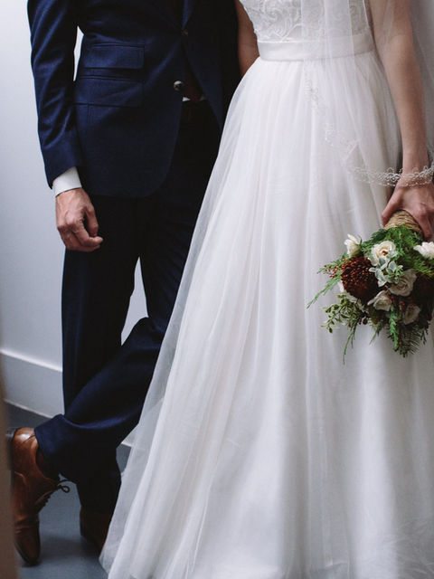 A bride and groom holding a bouquet of flowers