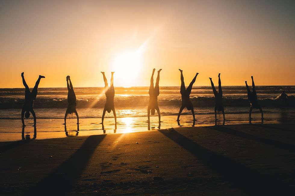 amigos fazendo handstand na praia ao por do sol