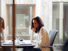 A professional pausing during a workplace presentation, appearing momentarily overwhelmed in a calm office environment.
