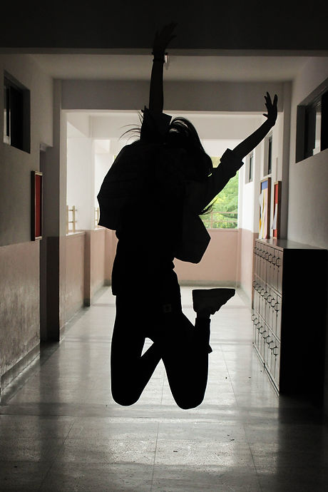 Teenager Jumping in School Hallway After Feeling Improvement from Counseling