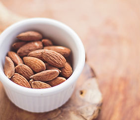 A small white dish of whole almonds