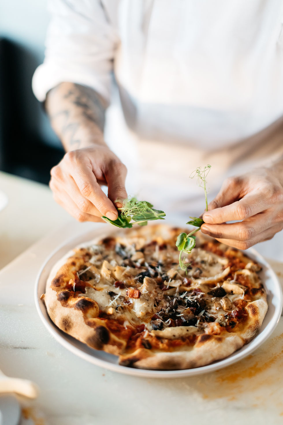 ean, pizzaiolo passionné de La Pizzologie, en pleine préparation d’une pizza signature