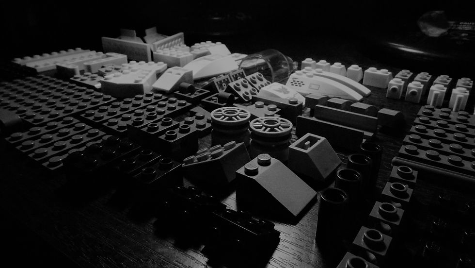 A grayscale photo of random lego pieces.