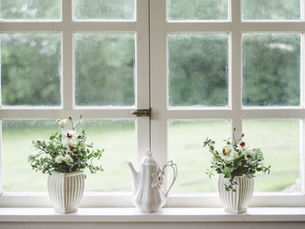 A window with white frames and decorated with flowers