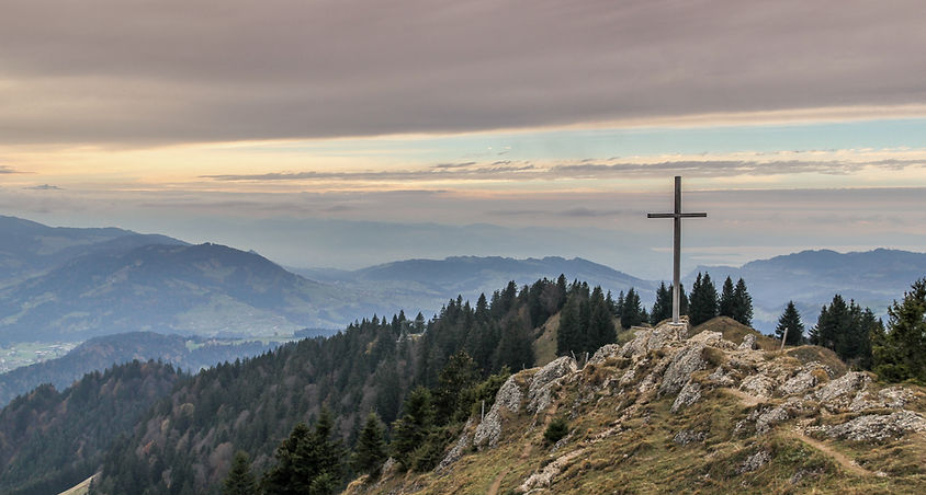 Cross on a hill overlooking mountain range
