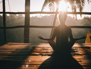 Woman meditating in tropical setting