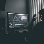 Guy editing videos on a PC