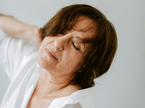 Femme avecla main sur son épaule, les yeux fermés