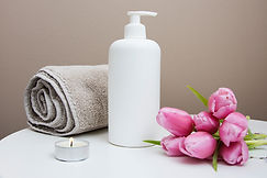 A photo of flowers, a towel and a bottle of massage cream.