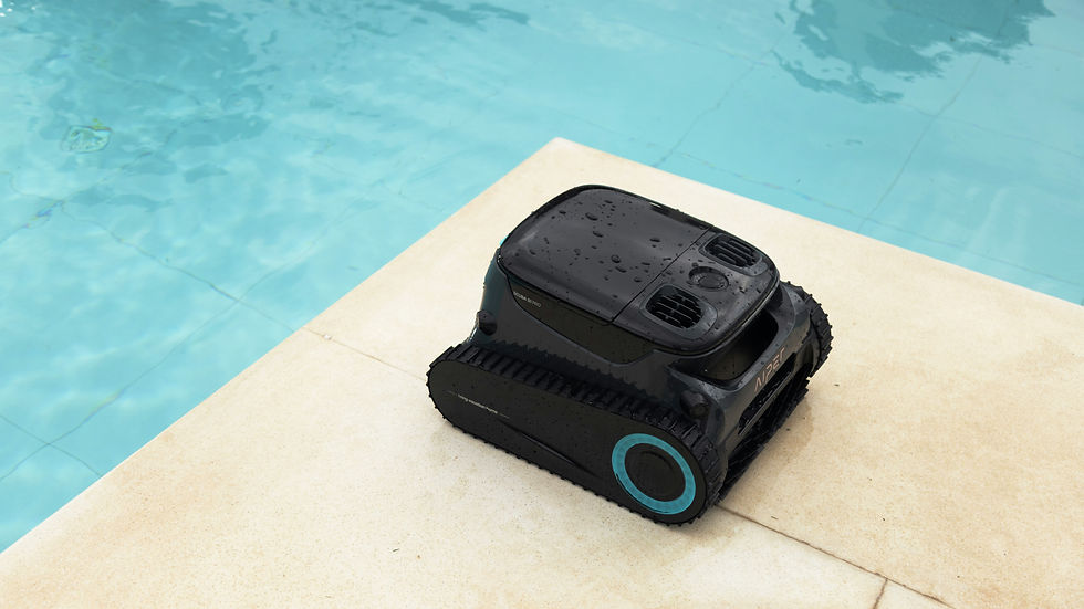 Black robotic pool cleaner on beige poolside, with raindrops, next to clear blue water.