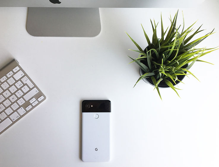 Minimal white office workspace used as a background image for audiology marketing FAQs