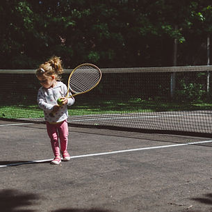 Child holding a racket as part of Growing Minds Playball programme
