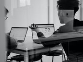 Two people on laptops discussing