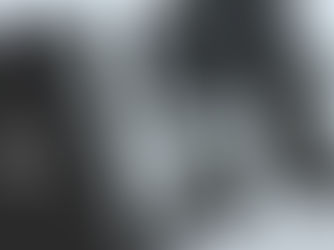 Masanın üzerinde bilgisayar, defter,saat, kalem, kulaklık, powerbank ve telefon