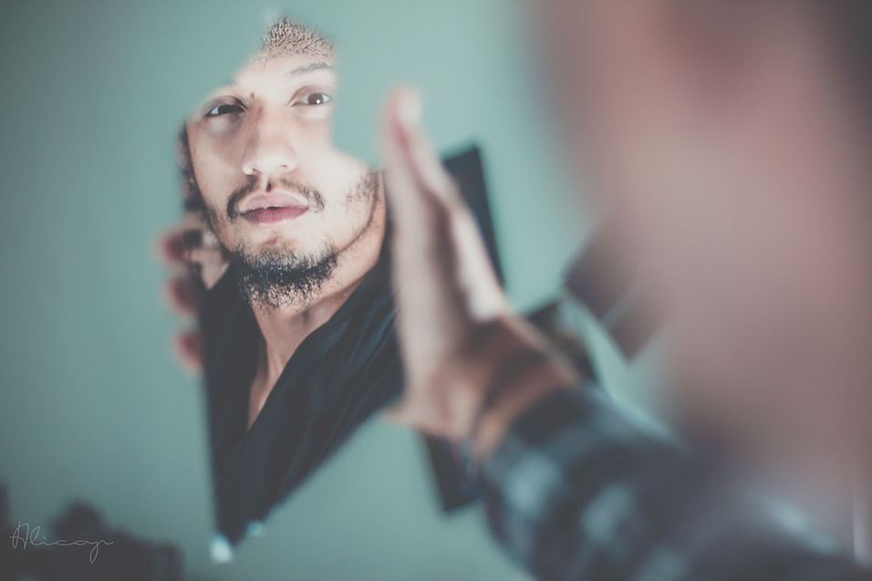 A man looking at his reflection in the mirror, symbolising reflection of spiritual ego