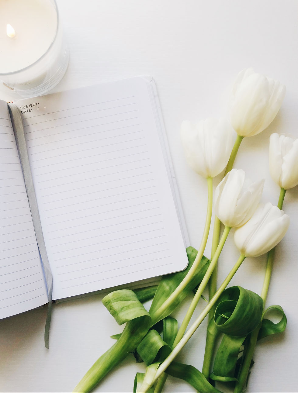 tables with flowers white candle and journal