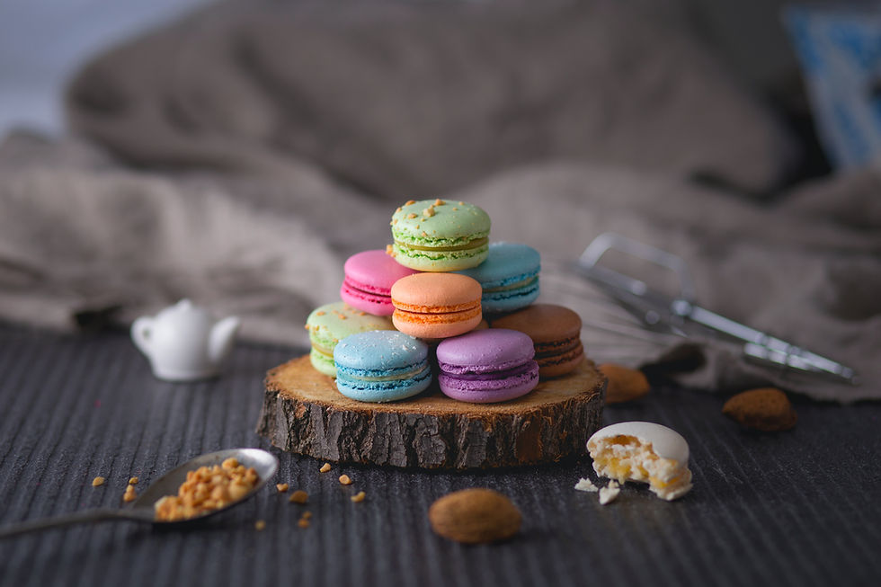 Image of multicoloured macarons piled up on a wooden plate