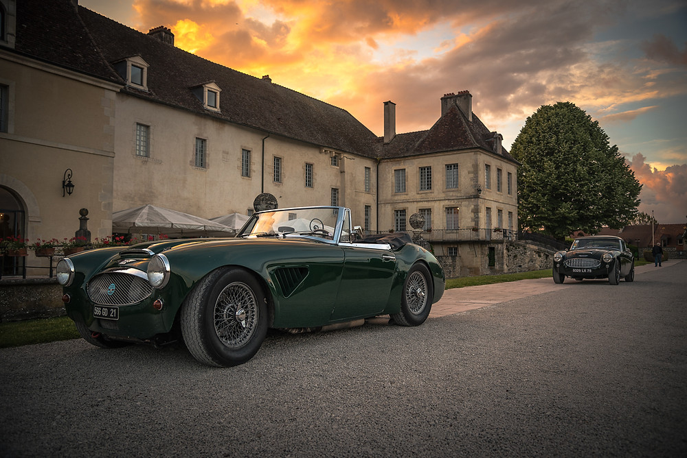 mansion with an antique Bentley car in front of it