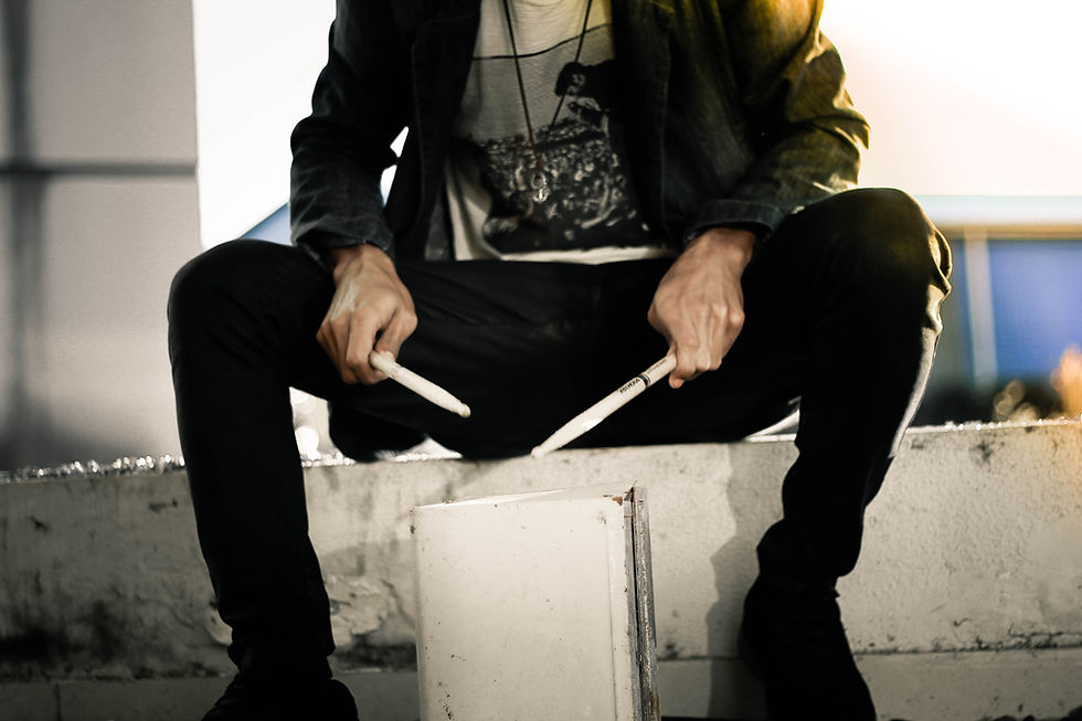 Person playing a bucket with drumsticks