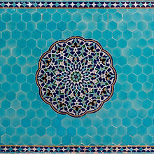 Turquoise hexagon tiles with intricate circular Persian mosaic design in blue and green.