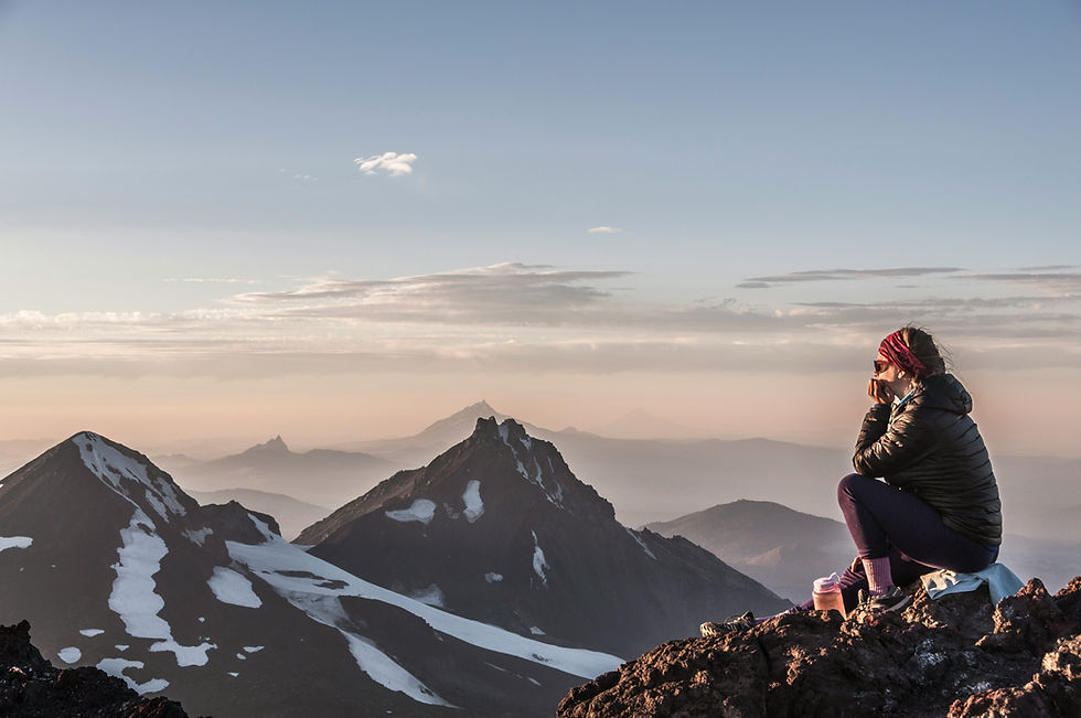 vrouw op de top van een berg turend in de vallei