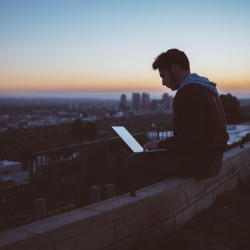 Person Sitting on rooftop working on laptop