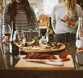 a group of women surrounding a table of food