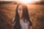 Natural headshot photograph of a young female during sunset in a field