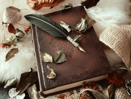 A leather journal with a quill pen for writing