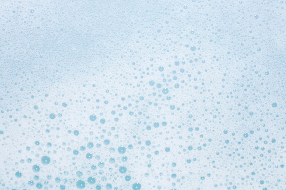 Close-up of light blue soap bubbles on a white background, creating a frothy texture with various bubble sizes and a refreshing feel.