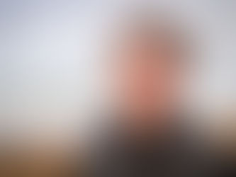 white male close up in casual clothes in front of tide on beach
