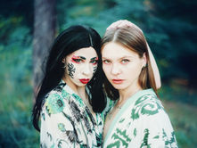 Dvě mladé ženy v kostýmu pózují parku