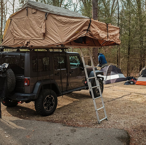 Dachzelt mit jeep und kuppelzelt im wald