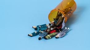 Miniature figurines spill from an orange pill bottle