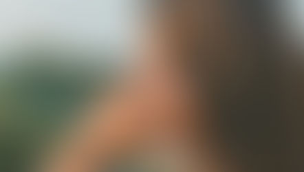 A woman in her 40s touching her ear with a thoughtful expression in soft morning light, representing perimenopause tinnitus and unexplained ringing in the ears during hormonal transition from Vibrance Way