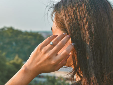 A woman in her 40s touching her ear with a thoughtful expression in soft morning light, representing perimenopause tinnitus and unexplained ringing in the ears during hormonal transition from Vibrance Way